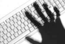 shadow of a hand over keyboard