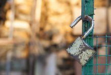 shutterstock 144587243 open padlock hanging on a green gate rusty padlock unlocked padlock