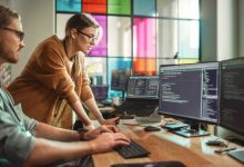 Male Data Scientist and Female Developer Working With Errors in Code on Desktop Computer in Creative Office. Caucasian Man and Woman Succesfully Fixed a Software Bug And High Five Each Other.