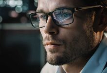 Portrait of Handsome Startup Digital Entrepreneur Working on Computer, Line of Code Reflecting in Glasses. Developer Working on Innovative e-Commerce Application using AI Algorithm to use Big Data