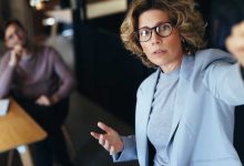 Business woman pitching an idea to her team in a meeting. Mature business woman giving a presentation in a boardroom. Team of professionals working together in a modern workplace.